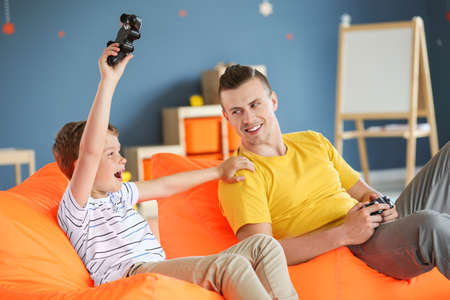 Portrait of father and son playing video game at homeの写真素材