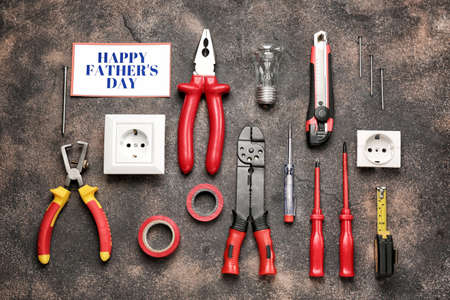 Different tools and card with text Happy Father's Day on grunge background