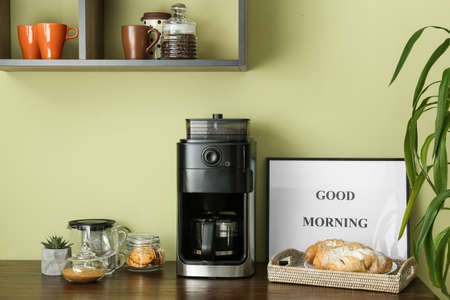 Modern coffee machine and sweets on kitchen tableの写真素材