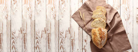 Tasty cut bread on white wooden table with space for text