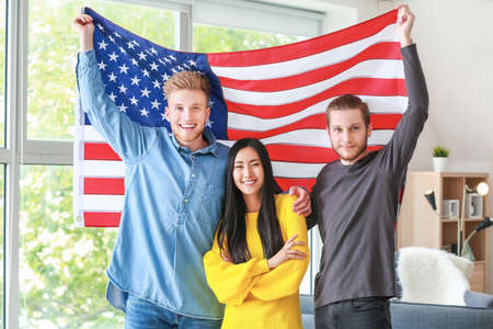 Happy friends with USA flag at home. Independence Day celebrationの写真素材