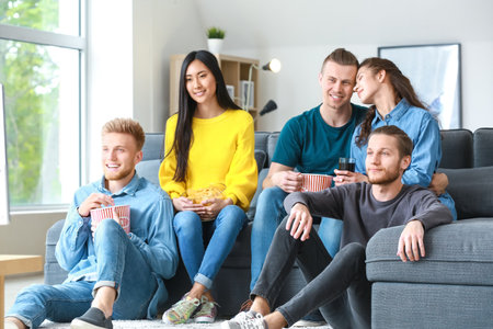 Friends watching TV at homeの写真素材