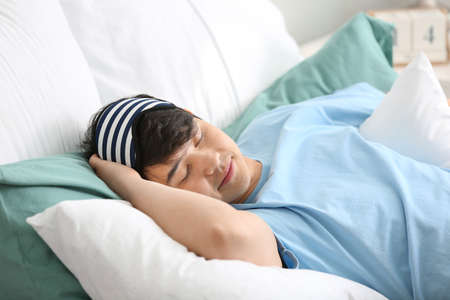 Handsome young man sleeping in bedの写真素材