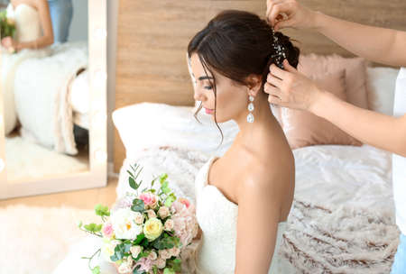 Professional hairdresser working with young bride at homeの写真素材