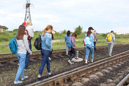 Group of illegal migrants walking along railway tracks