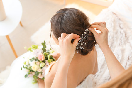 Professional hairdresser working with young bride at homeの写真素材