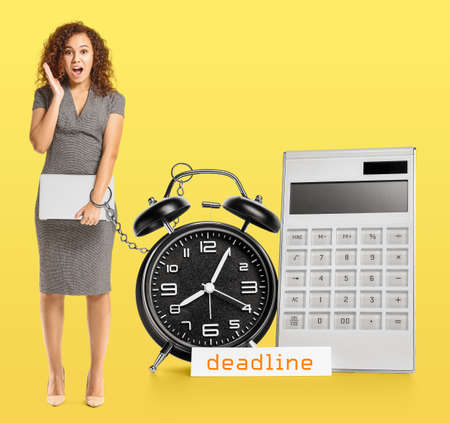 Shocked African-American businesswoman chained to alarm clock on color background. Deadline concept