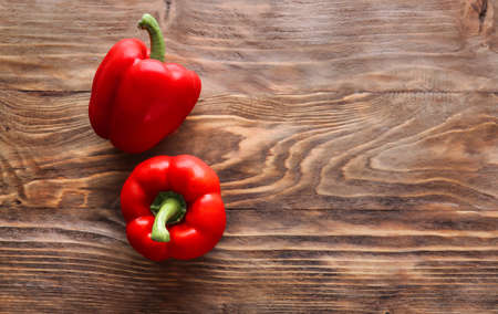 Ripe red peppers on wooden backgroundの写真素材