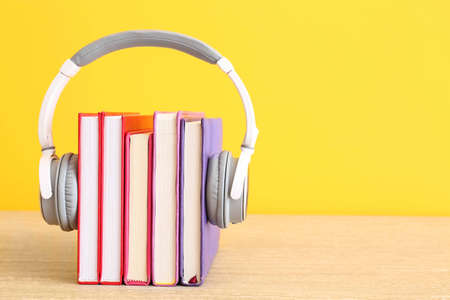 Books and modern headphones on table. Concept of audiobookの写真素材