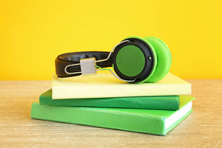 Books and modern headphones on table. Concept of audiobookの写真素材