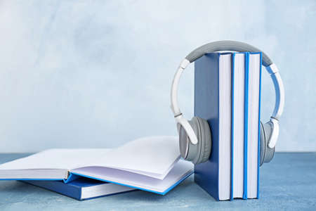 Books and modern headphones on table. Concept of audiobookの写真素材