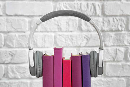 Books and modern headphones on white background. Concept of audiobookの写真素材