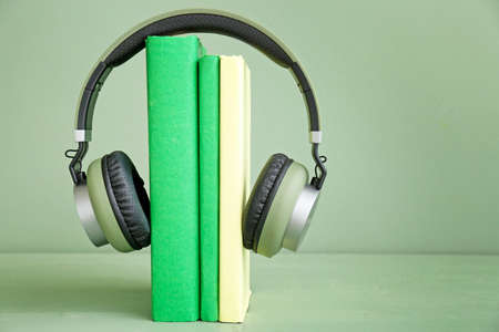 Books and modern headphones on table. Concept of audiobookの写真素材