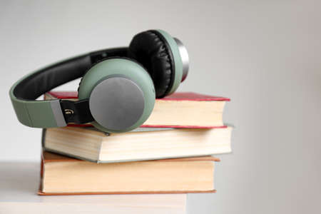 Books and modern headphones on table. Concept of audiobookの写真素材