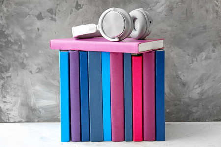 Books and modern headphones on table. Concept of audiobook
