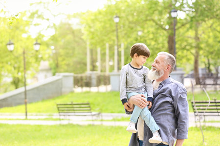 Cute little boy with grandfather in parkの写真素材