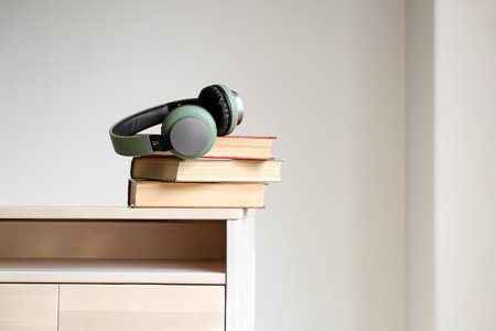 Books and modern headphones on table. Concept of audiobookの写真素材