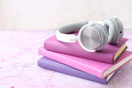 Books and modern headphones on table. Concept of audiobookの写真素材