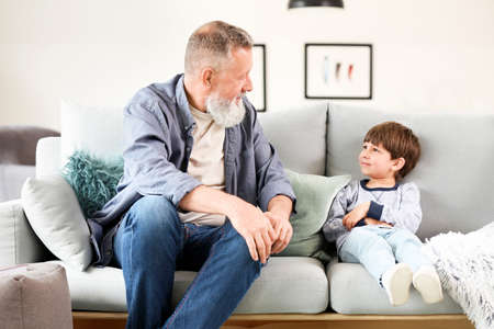 Cute little boy with grandfather at homeの写真素材
