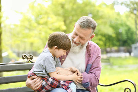 Cute little boy and his grandfather playing in parkの写真素材