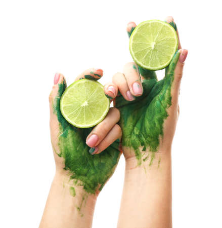 Painted female hands with lime on white backgroundの写真素材