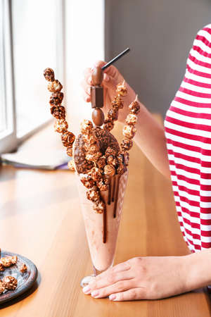 Woman with delicious freak shake in cafeの写真素材