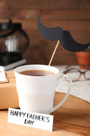 Cup of coffee, greeting card for Father's Day and gift on tableの写真素材