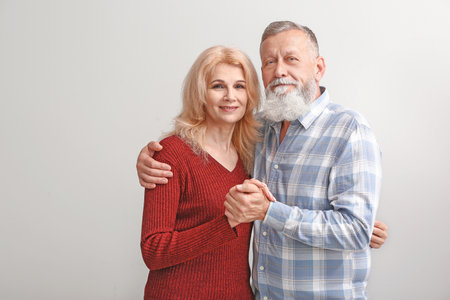 Portrait of mature couple on light background