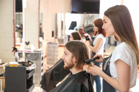 Female hairdresser working with client in salonの写真素材