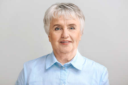 Portrait of elderly woman on light background