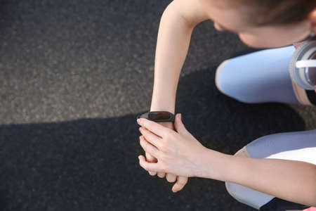 Sporty young woman checking her pulse at the stadiumの写真素材