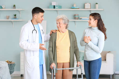 Doctor visiting senior woman at homeの写真素材