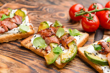 Tasty toasts with bacon on wooden board, closeupの写真素材