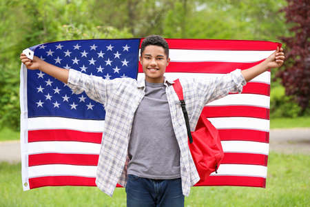 African-American student with USA flag outdoorsの写真素材