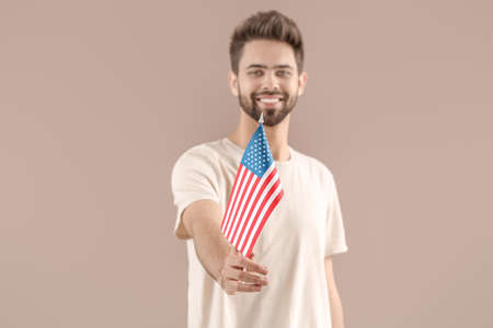 Young man with USA flag on color backgroundの写真素材