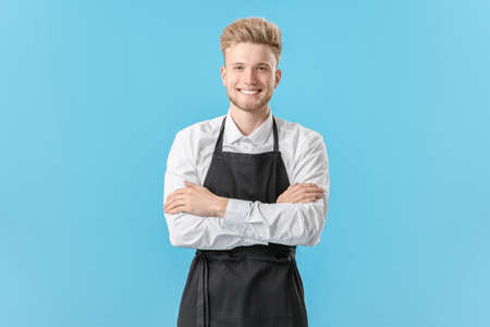 Handsome male chef on color background