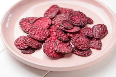 Plate with tasty beet chips on table, closeupの写真素材