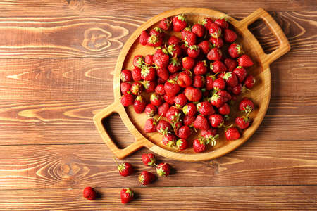 Tray with ripe red strawberry on wooden backgroundの写真素材