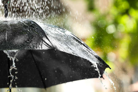 Black umbrella outdoors on rainy dayの写真素材