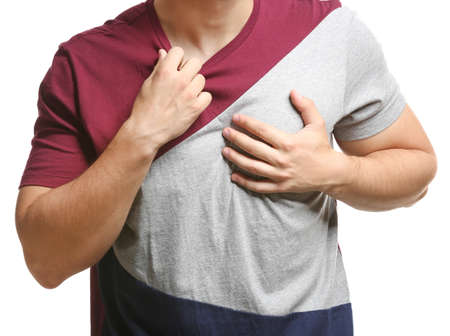 Young man suffering from heart attack on white background, closeup