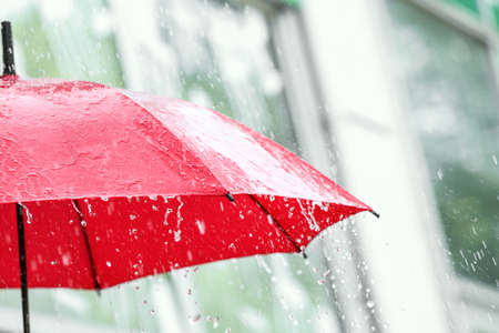 Red umbrella outdoors on rainy day