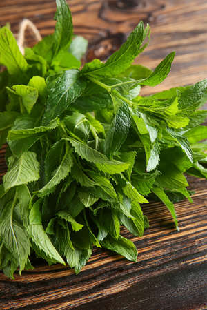 Bunch of fresh mint on wooden background, closeup