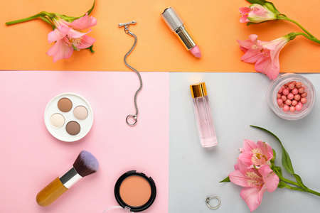Decorative cosmetics and flowers on color backgroundの写真素材