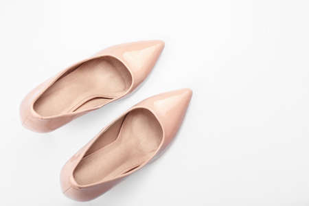 Pair of stylish high-heeled female shoes on white background