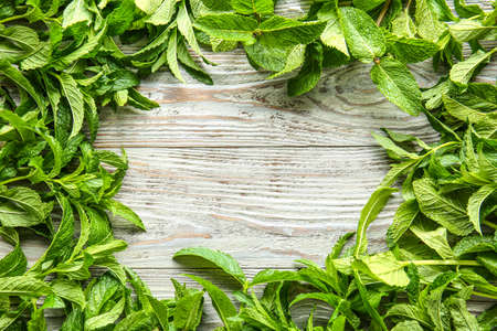 Frame made of fresh green mint on wooden background