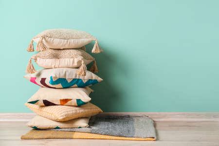 Soft pillows on floor near color wall