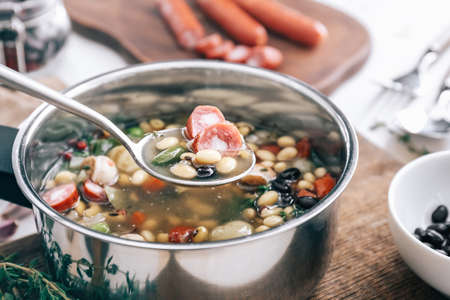 Tasty soup with legumes in saucepan on tableの写真素材