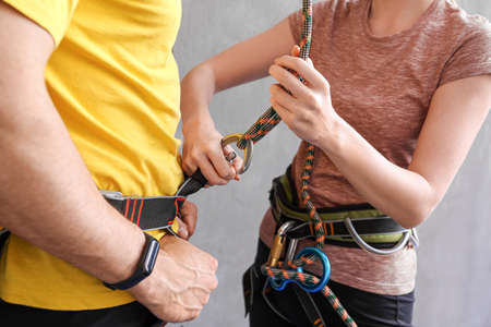 Instructor teaching young man to put on climbing gear in gymの写真素材