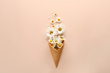 Composition with waffle cone and beautiful flowers on color backgroundの写真素材