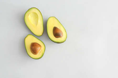 Halves of ripe avocado on white backgroundの写真素材